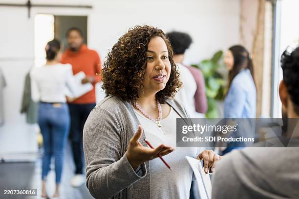 woman leading a group discussion, teamwork and collaboration - film script stock pictures, royalty-free photos & images