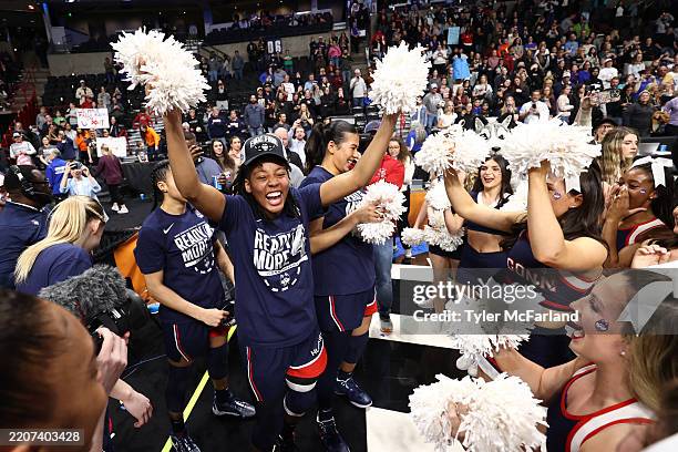 UConn Huskies players celebrate with the band and cheerleaders after their 78-64 win over the USC Trojans during the Elite Eight round of the 2025...