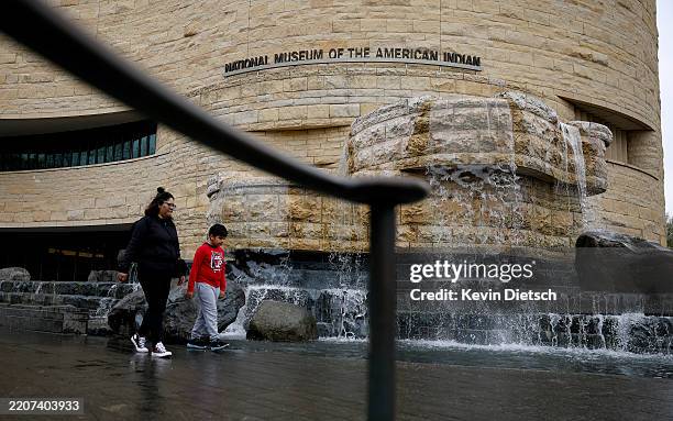 People walk past a fountain at the Smithsonian's National Museum of the American Indian on the National Mall on March 28, 2025 in Washington, DC....