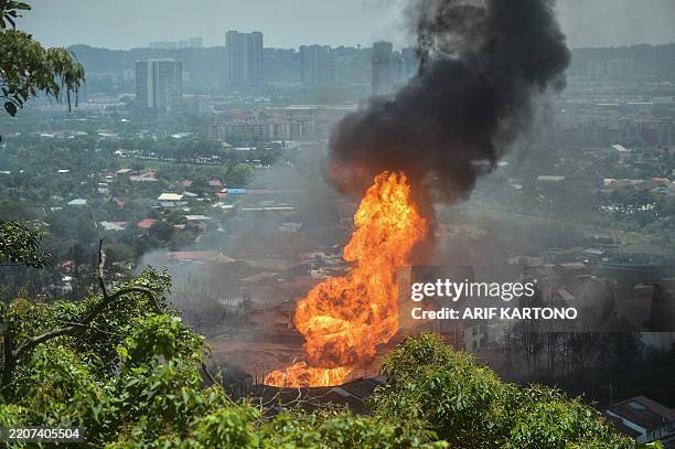 Smoke rises from a fire caused by a gas pipeline leak in Puchong, Selangor on April 1, 2025. A massive fire forced people from their homes during Eid...