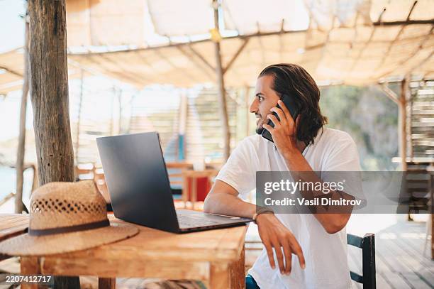 digital nomad working at a beach bar. - sitting on beach stock pictures, royalty-free photos & images