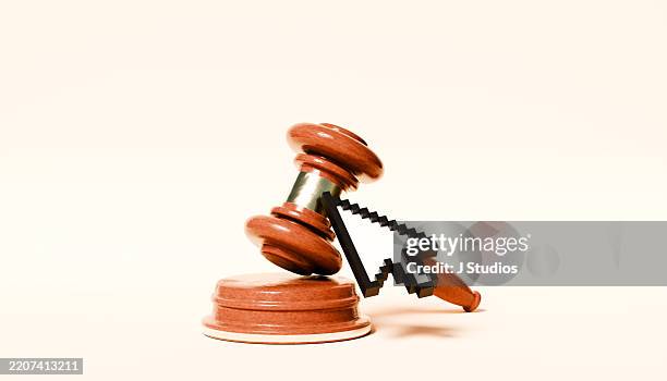mouse cursor in front of large gavel – law and justice concept - versteinerung stock-fotos und bilder
