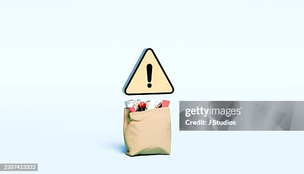 grocery shopping bag with yellow warning triangle hovering above – consumer awareness and safety - verkehrswarnung stock-fotos und bilder