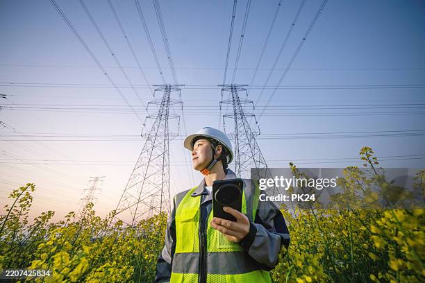 asian female engineer using smart phone in power station - electricity substation stock pictures, royalty-free photos & images