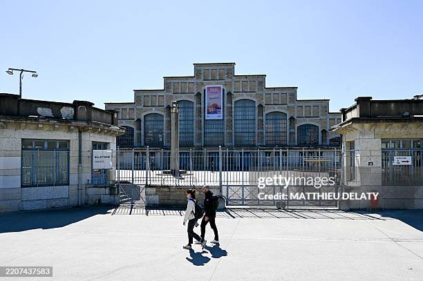 People walk in front of the facade of the Tony Garnier Hall during the visit of Tourism Minister Nathalie DELATTRE to the RENDEZ VOUS IN FRANCE trade...