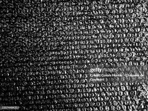 black bubble plastic wrap with shadow and noise effect. rough texture. natural light. paris, france. - bubble sheet stock pictures, royalty-free photos & images