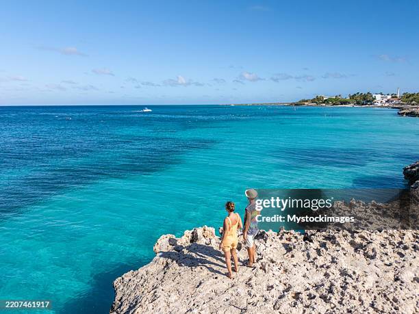 couple enjoying scenic coastal view from rocky shoreline - wonderlust imagens e fotografias de stock