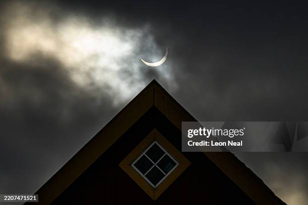Traditional Greenlandic home is silhouetted during a partial solar eclipse on March 29, 2025 in Nuuk, Greenland.