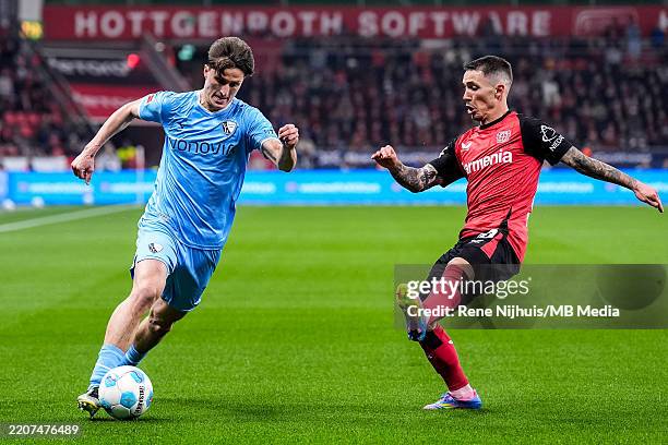 Tim Oermann of VfL Bochum dribbles with the ball under pressure from Alex Grimaldo of Bayer 04 Leverkusen during the Bundesliga match between Bayer...