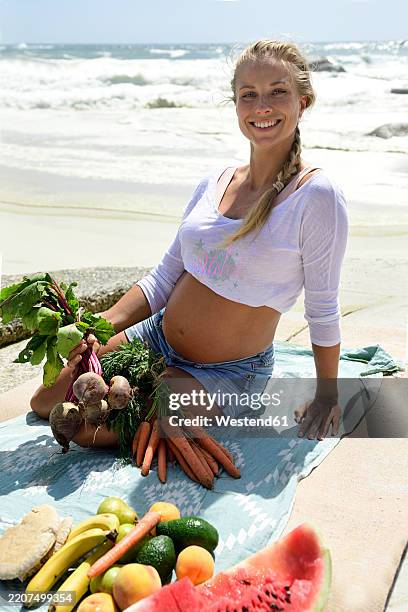 portrait of smiling pregnant woman on the beach with healthy picnic - camps bay stock pictures, royalty-free photos & images