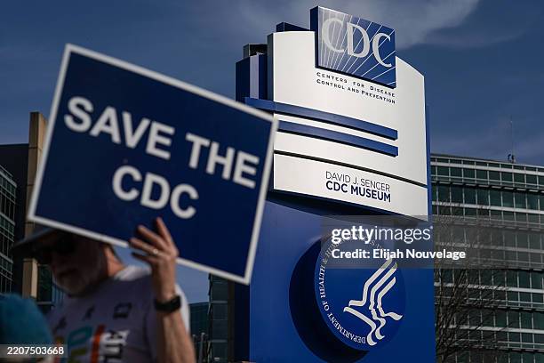 Man holds up a sign outside the main campus of the Centers For Disease Control and Prevention on April 1, 2025 in Atlanta, Georgia. Health and Human...
