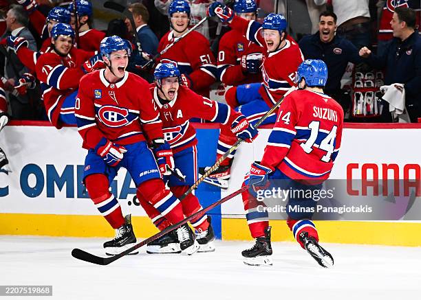 Nick Suzuki of the Montreal Canadiens celebrates his game-winning overtime goal with teammates Juraj Slafkovský and Brendan Gallagher against the...