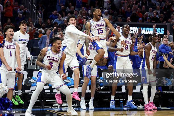 Will Richard, Alijah Martin and Rueben Chinyelu of the Florida Gators celebrate with teammates on the bench against the Maryland Terrapins during the...