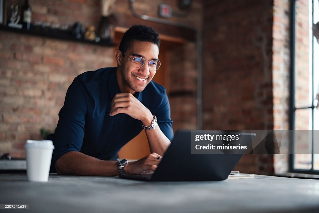 Jovem profissional trabalhando no laptop em ambiente de escritório moderno