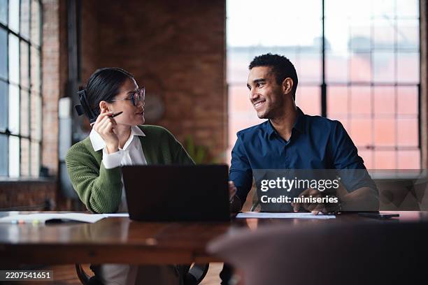 two professionals collaborating in a modern office setting with natural light - design studio wall stock pictures, royalty-free photos & images