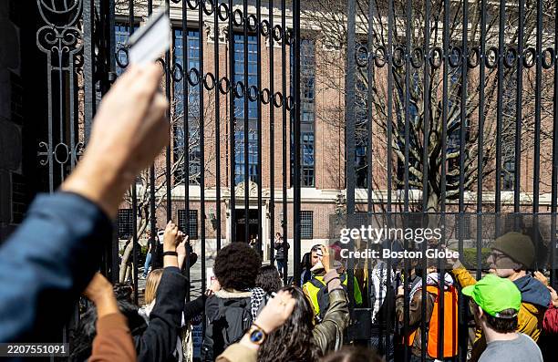 Cambridge, MA Protesters show their Harvard ID's as security guards try to close the gate to Harvard University. Students gathered to demonstrate...
