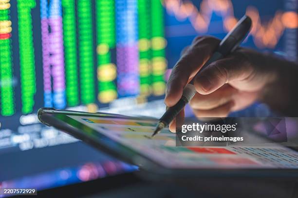 a business professional using a tablet artificial intelligence model charts displaying a smart trading interface powered ai with detailed charts and graphs for informed trading decisions - fashion model stock pictures, royalty-free photos & images