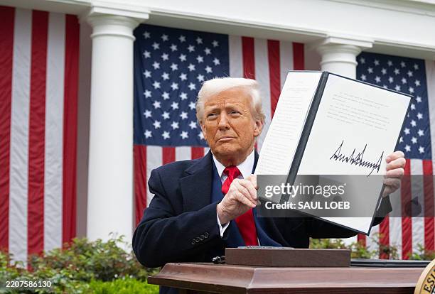 President Donald Trump holds a signed executive order after delivering remarks on reciprocal tariffs during an event in the Rose Garden entitled...