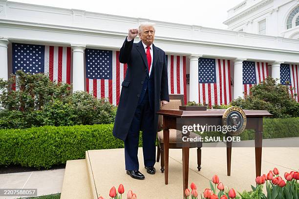 President Donald Trump pumps his fist after signing an executive order after delivering remarks on reciprocal tariffs during an event in the Rose...