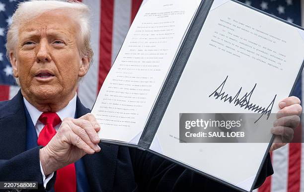 President Donald Trump holds a signed executive order after delivering remarks on reciprocal tariffs during an event in the Rose Garden entitled...