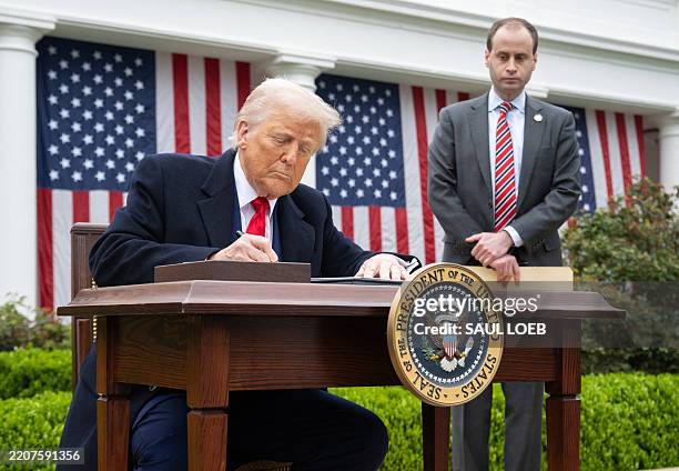 President Donald Trump signs an executive order after delivering remarks on reciprocal tariffs during an event in the Rose Garden entitled "Make...