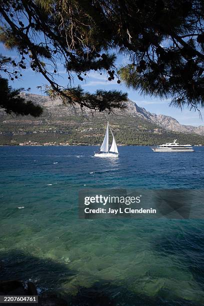 Sailboat and yacht seen the aqua colored water, off the coastline of old town Korcula, Croatia, in the Adriatic Sea of Europe, photographed July 14,...