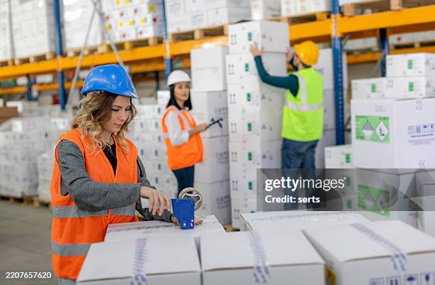 warehouse team performing packaging, stacking, and loading tasks in a busy logistics facility. - stacking boxes stock pictures, royalty-free photos & images