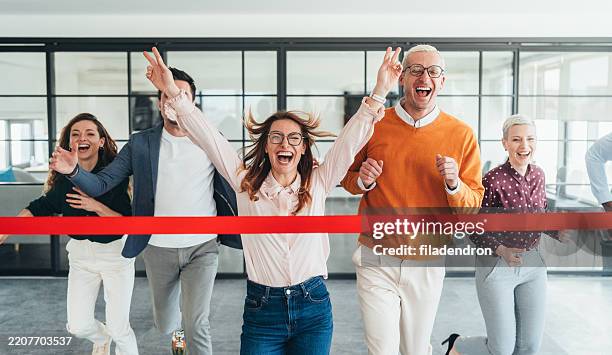 celebración del equipo cruzando la línea de meta en un entorno de oficina - rivalidad fotografías e imágenes de stock