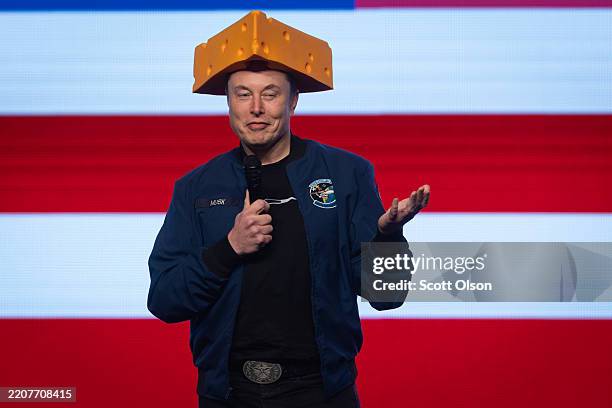 Billionaire businessman Elon Musk arrives for a town hall wearing a cheesehead hat at the KI Convention Center on March 30, 2025 in Green Bay,...