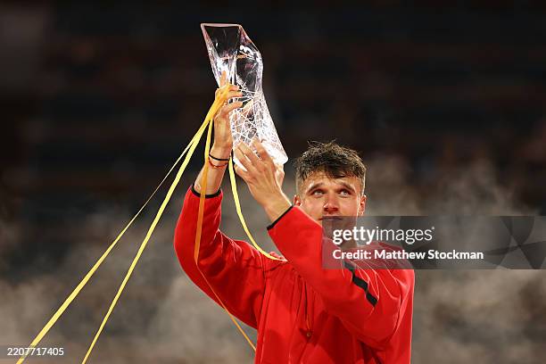 Jakub Mensik of the Czech Republic lifts the championship trophy after defeating Novak Djokovic of Serbia during the men's singles final on the final...