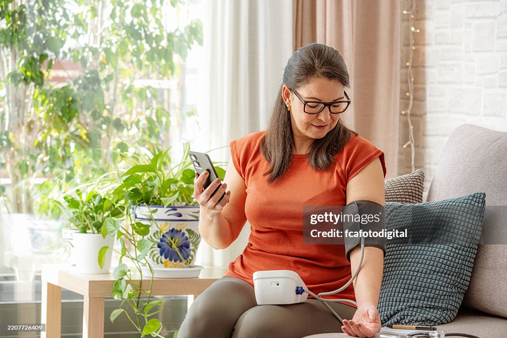 Mature woman using phone to talk with her Doctor about her blood pressure