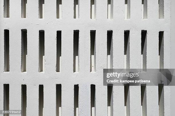 a wall with a pattern of holes in it - perforated metal stock pictures, royalty-free photos & images