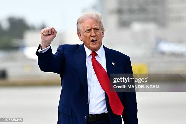 President Donald Trump pumps his fist upon arrival at Miami International Airport on April 3, 2025. Trump is travelling to the Trump National Doral...