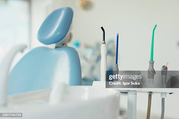 dentist tools and chair waiting for the next patient in a dental office - cadeira de dentista imagens e fotografias de stock