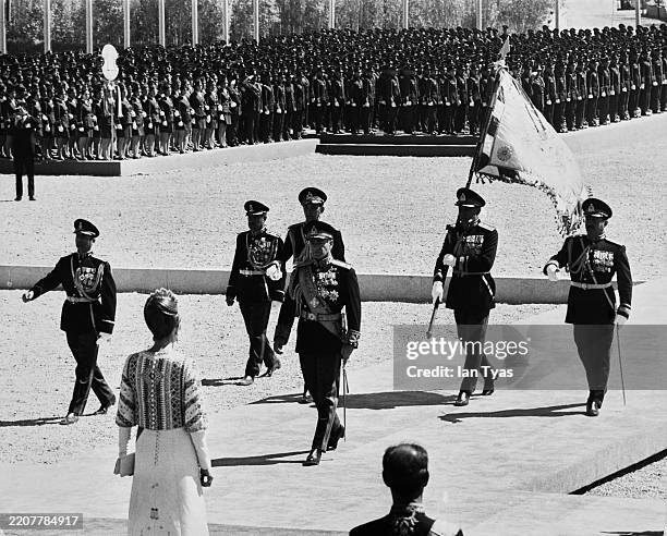 Mohammed Reza Pahlavi , the Shah of Iran, walks back towards waiting Empress Farah Pahlavi after laying a wreath at the tomb of Cyrus the Great in...