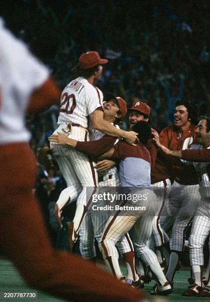Third baseman Mike Schmidt celebrates with pitcher Tug McGraw and other Philadelphia Phillies teammates after winning the World Series championship...