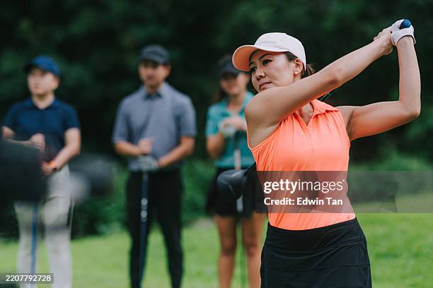 asiatische chinesische golferin spielt golf auf golfplatz wochenendmorgen mit freunden - golfturnier stock-fotos und bilder
