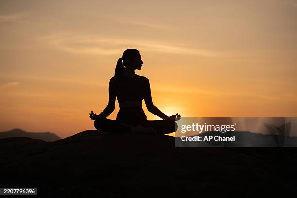 Silhouette of  sport woman striking a graceful yoga pose against the glowing. This image perfectly represents the essence of meditation, wellness, and the pursuit of balance in life.