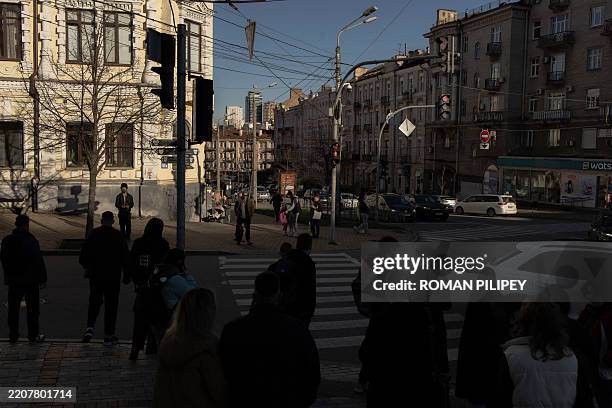 Pedestrians wait to cross a street in Kyiv on April 3 amid the Russian invasion of Ukraine.