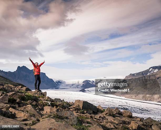 mature man standing in skaftafell national park, looking at vatnajokull glacier, iceland - parc national de skaftafell photos et images de collection
