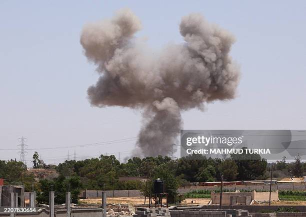 Smoke billows from a spot targeted by a NATO air strike on July 1, 2011 in the Tripoli suburb of Tajura, as African Union leaders resumed talks in...