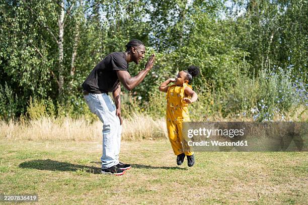 father and daughter high fiving in a park - cute italian girls stock pictures, royalty-free photos & images