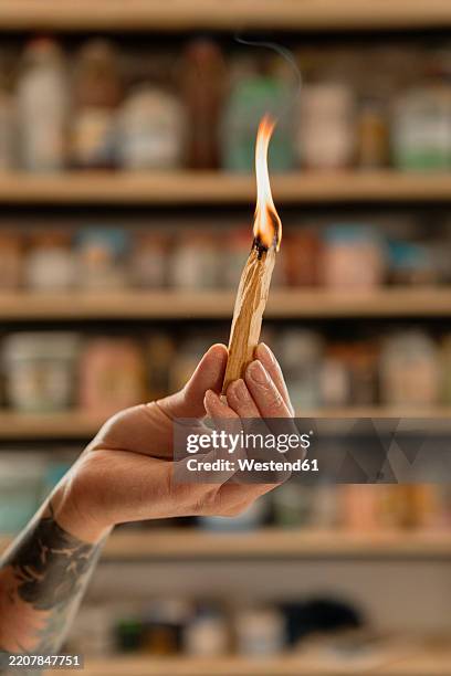 woman holding stick of burning palo santo - meditation on fire stock pictures, royalty-free photos & images