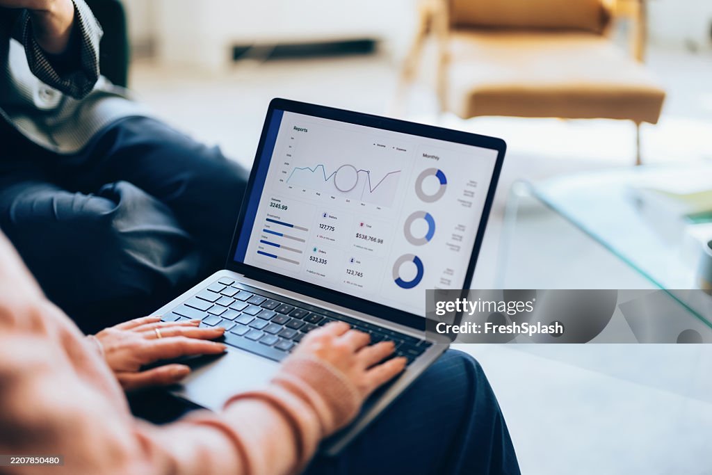 Person, die Geschäftsdaten auf einem Laptop in einer modernen Büroumgebung analysiert