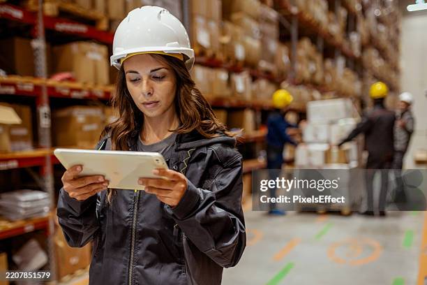 smart warehousing: female employee optimizing logistics with technology - clever storage stock pictures, royalty-free photos & images