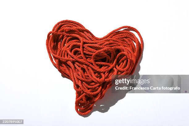 heart created with red cotton thread - lana foto e immagini stock