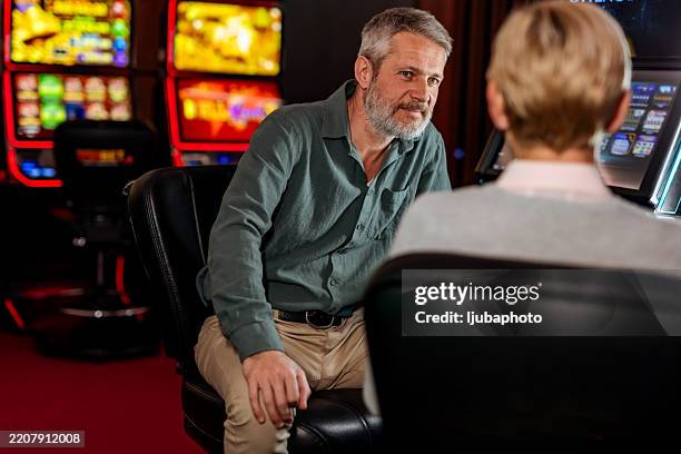 two individuals in conversation in a casino environment - casino worker stock pictures, royalty-free photos & images