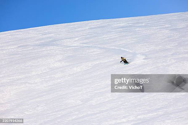 skier carving through fresh powder in the backcountry - heli skiing stock pictures, royalty-free photos & images