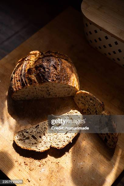sliced loaf of bread with seeds on wooden cutting board - rye bread stock pictures, royalty-free photos & images