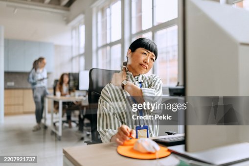 Businesswoman having neck ache due to work over load and bad posture Businesswoman having neck ache due to work over load and bad posture